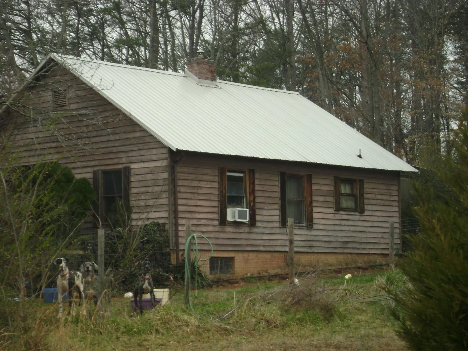 White metal roof on an old wood sided farmhouse, from a Asphalt Shingle Roof Repair job in Rapids City